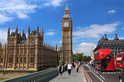 People walking on a bridge in London, with Big Ben and the houses of parliament in the background.