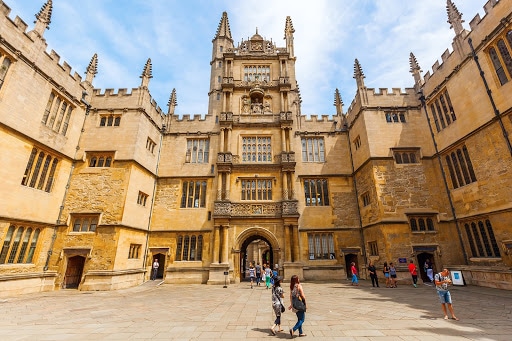 People walking in front of Oxford University in Oxford, England.