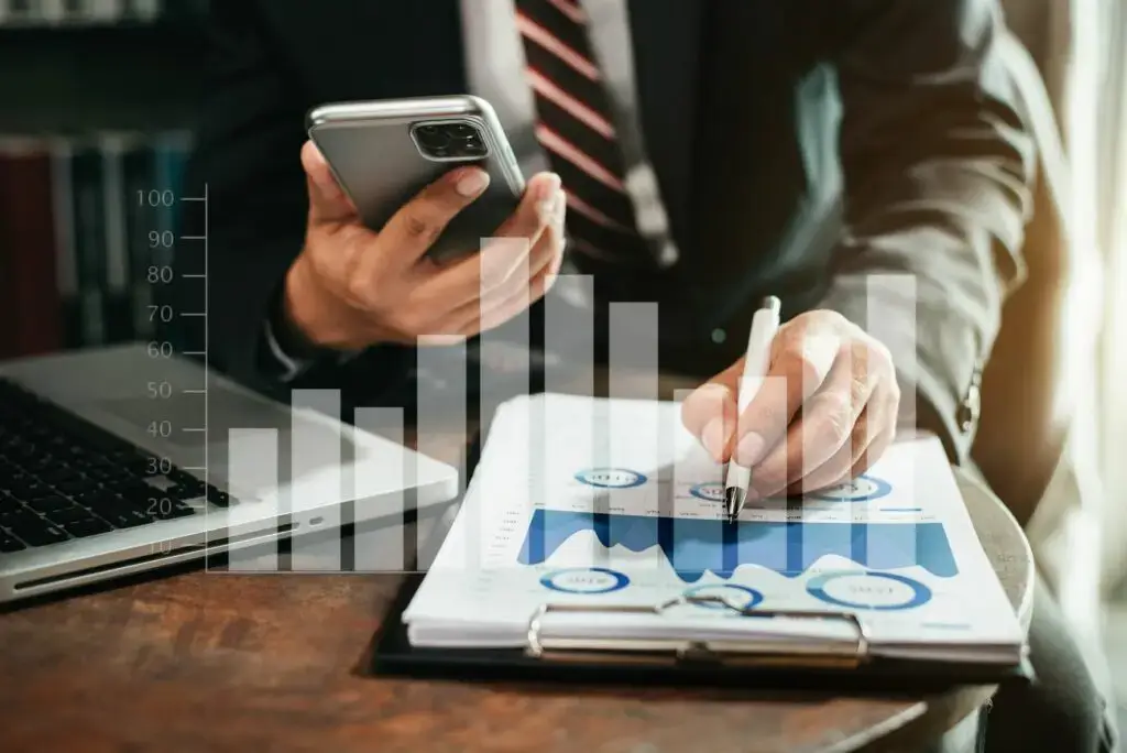 Business man calculate and analyzing graph document financial with laptop