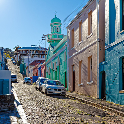Old cobbled street with mosque and brightly coloured houses in the Bo-Kaap area of the Cape Town CBD, South Africa