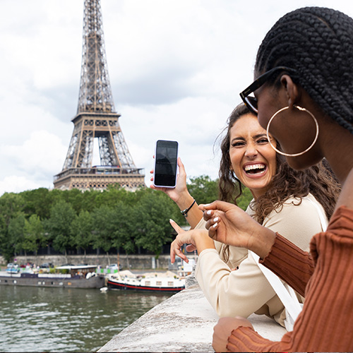 women looking at a phone while in paris