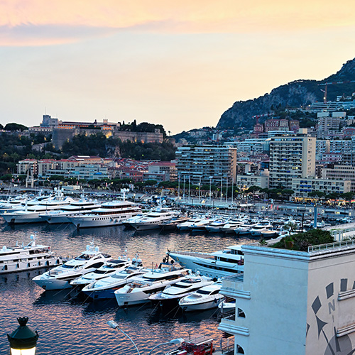 Cityscape of Monaco at sunset Sea port with moored yachts residential buildings and streets