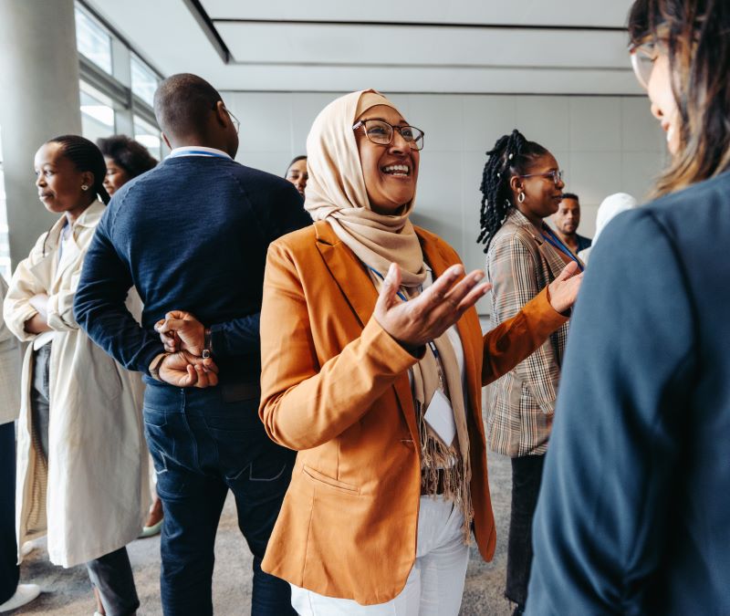 Smiling Muslim businesswoman sharing and talking during a networking event