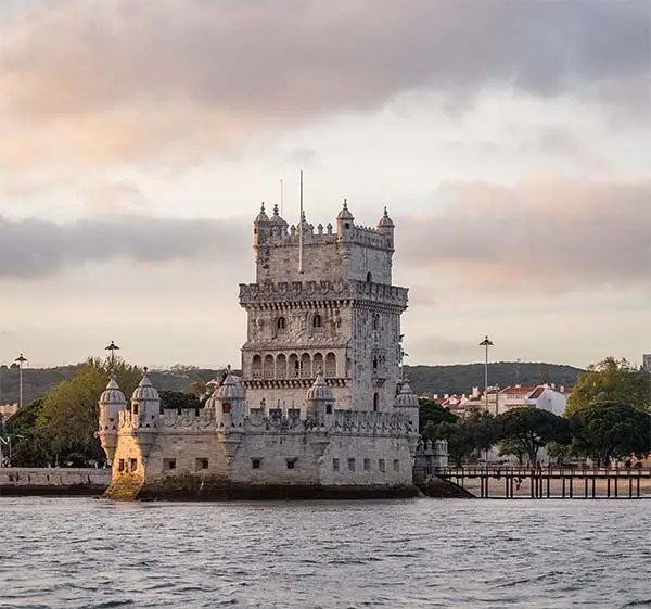 tower-belem-surrounded-by-sea-buildings-cloudy-sky-portugal