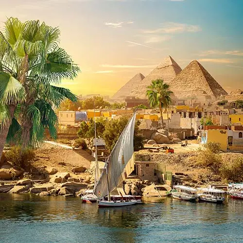 River nile and boats at sunset in aswan and pyramids